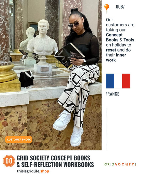 Customer reading a Grid Society Concept Book inside a gallery in Paris, France, integrating inner work into their holiday reading list.