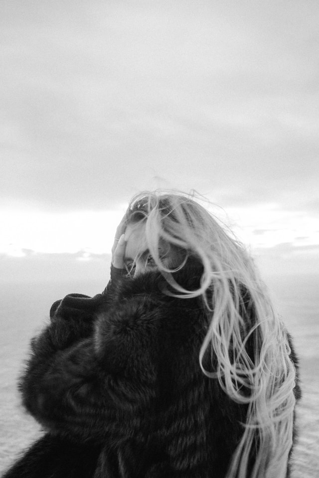 Black-and-white image of a woman looking upward while emotionally overwhelmed, symbolising the exhaustion of comparing your private struggles, insecurities, and flaws to other people’s polished online image.