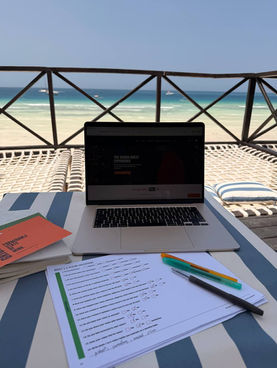 Workspace setup during Vision Quest online workshop with notebook, laptop and planning materials photographed in Zanibar