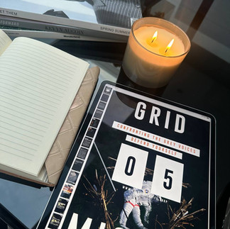 Cosy candle-lit journaling session featuring the Building Boundaries workbook, notebook, and Grid Society sticker, promoting reflection and quiet focus.