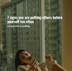 Woman sitting by a window looking at her phone, reflecting on putting others before yourself and feeling emotionally distant.