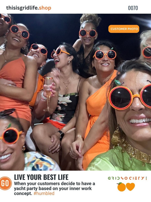 Group of women celebrating on an orange-themed yacht inspired by Grid Society workshops. Represents joy, connection, and how inner work becomes a lifestyle.