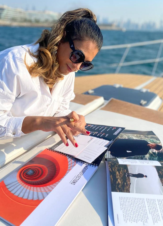 Woman using notebook and Grid Society materials on a boat, showing structured planning and personal development in a real-life setting