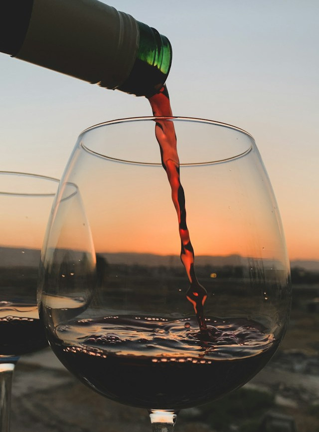 “Evening reflection with a glass of wine for exploring why achieving your goals can still leave you feeling empty.”
