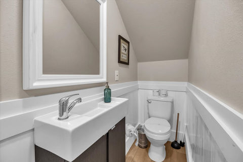 Small bathroom with white sink, mirror, and toilet.