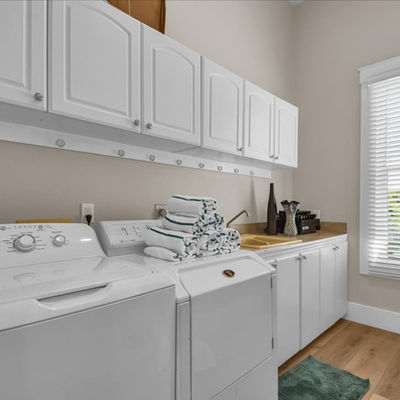 Laundry room with white cabinets and appliances