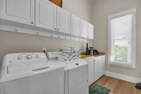 Laundry room with white cabinets and appliances