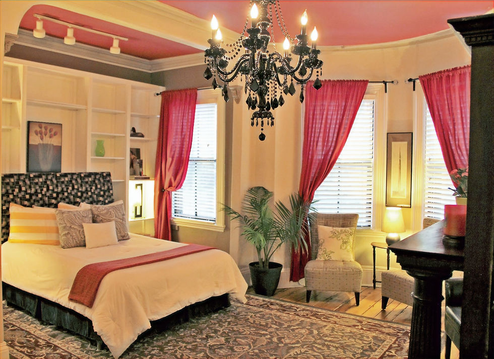 Bedroom with bed, chandelier, windows, and curtains. Fort Hill Inn offers short-term Boston stays.