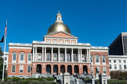 Massachusetts State House building with gold dome standing tall on a sunny day.