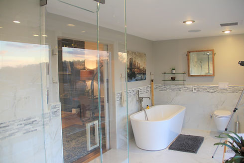 Modern bathroom with a white tub and glass shower doors forthillinn.