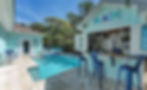Light blue outdoor bar with BEACH sign, swimming pool, and lounge chairs