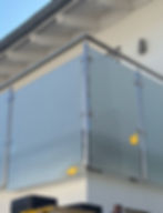 Moderner Balkon mit Glasgeländer und Edelstahlpfosten.
