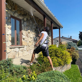 ouvrier qui nettoie la maison au jet d'eau