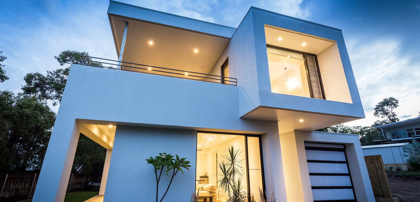 Modern white two-story house at dusk