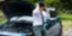 male on the telephone leaning on a car