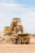 Mine Digger emptying sand into dump truck