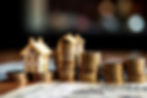 Mini home figurine surrounded by copper coins