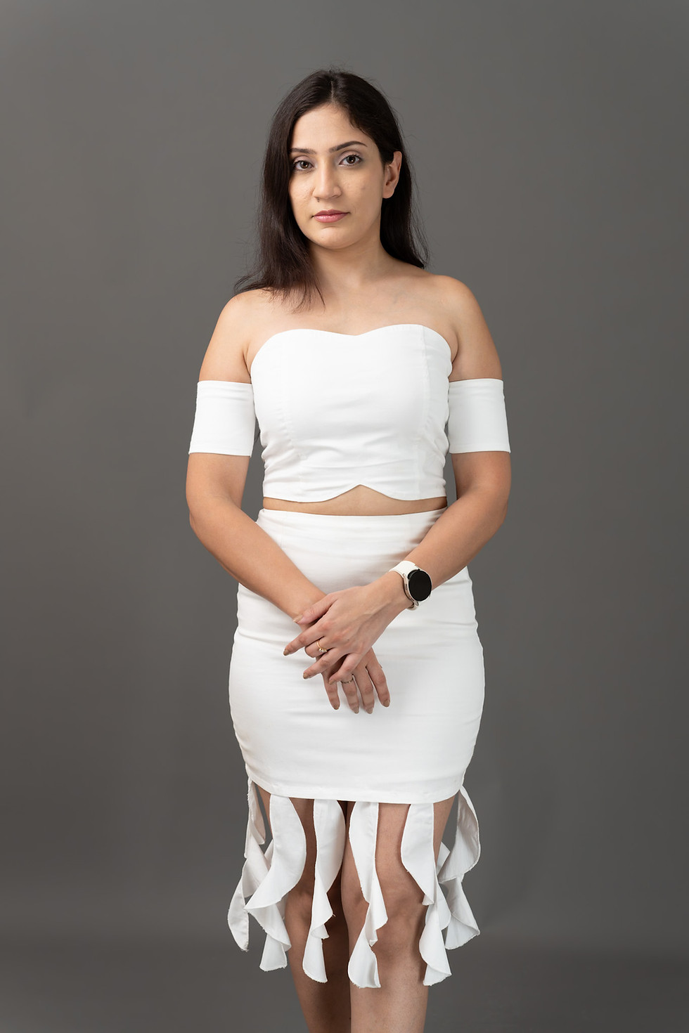 Woman in white off-shoulder crop top and matching skirt