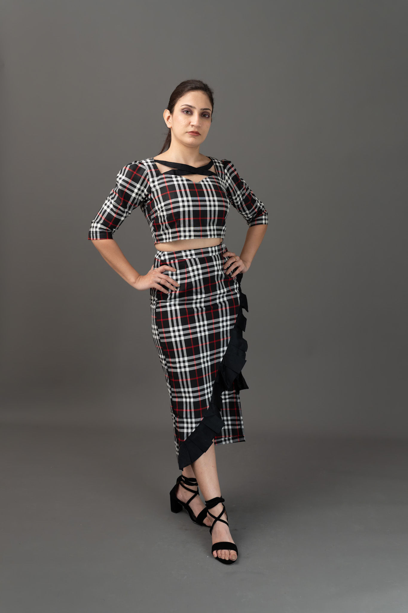 Woman in black, white, red plaid crop top and ruffled skirt