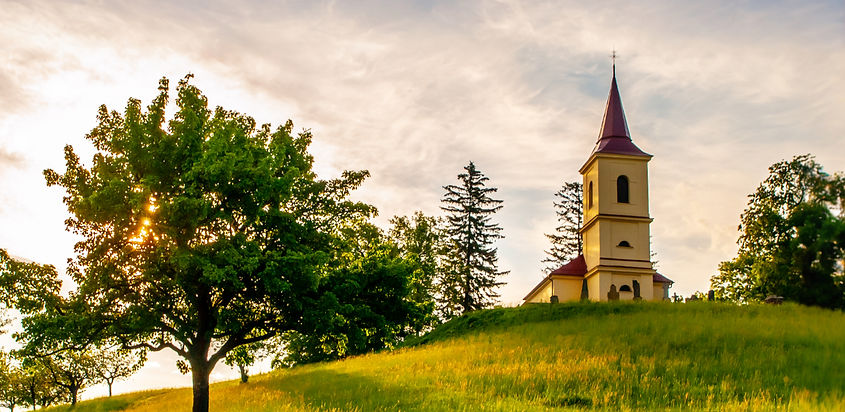 Small church in the middle of lush green spring landscape on sunny day. St. Peter and Paul
