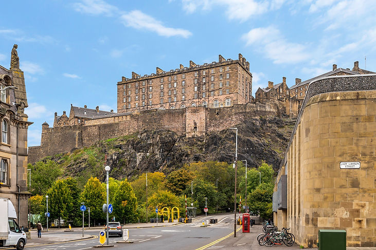 Edinburgh Castle on a rocky hill with a street below