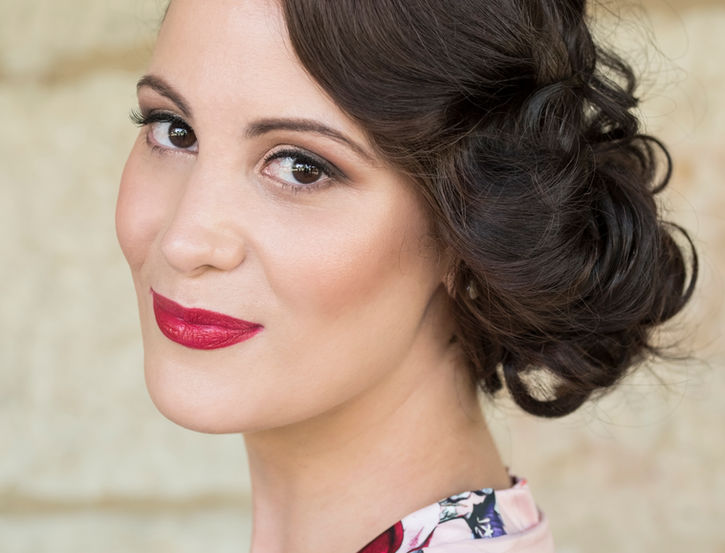 Beautiful woman with elegant updo, red lipstick, and floral robe.