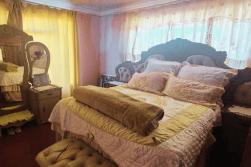 Well-furnished guest bedroom with warm natural light at South African homestay.