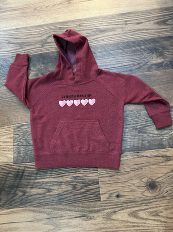child's burgundy sweatshirt with a row of pink hearts and the words grammy loves me above