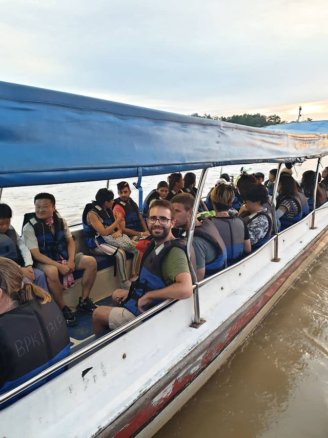 Adventurous boat ride along the Selangor River, surrounded by lush greenery and under a clear blue sky, offering a serene and immersive nature experience.