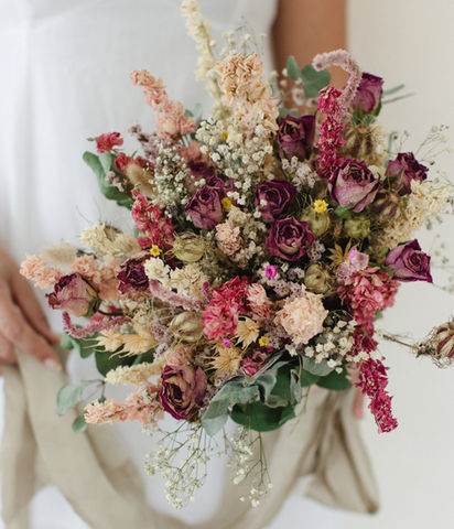 A Wedding bouquet wuth dried flowers featuring dried red roses.