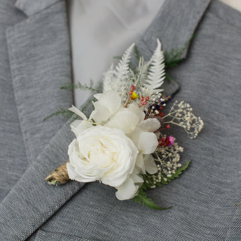 white wedding flower for gooms. This dried flower buttonhole has a white rose.