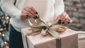 Frauenhände packen ein Geschenk aus