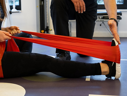 Dehnungsband um einen Fuß beim Training mit Personaltrainer