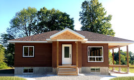 Single storey home with covered deck. Covered front entry with a large window to the left. Brown wood siding, white trim and brown shingle roof 