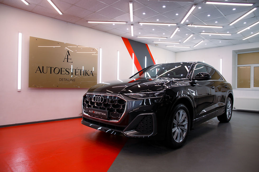 Melns Audi SUV autoestētikas salonā ar spīdīgām gaismām un Autoestētika Detailing zīmi.