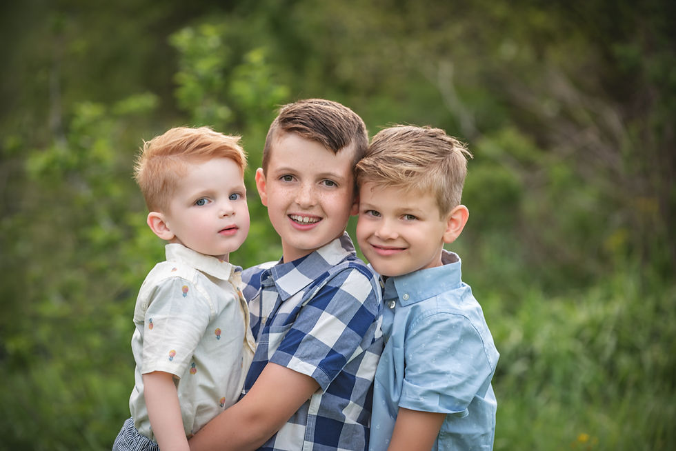 Three brothers sitting together outdoors during family location portraits in Utah