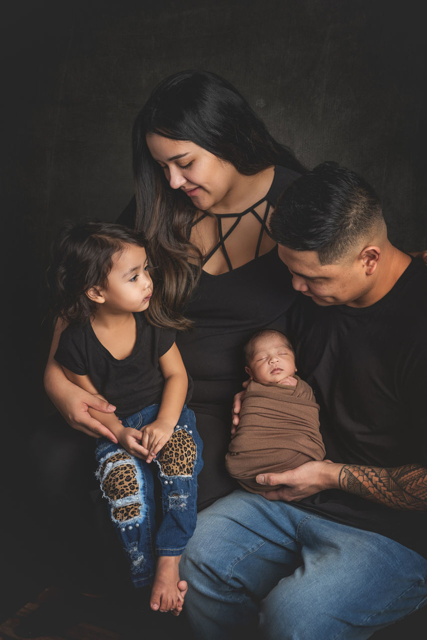 Parents and sibling with newborn during a family newborn portrait at La Bella Sole Photography