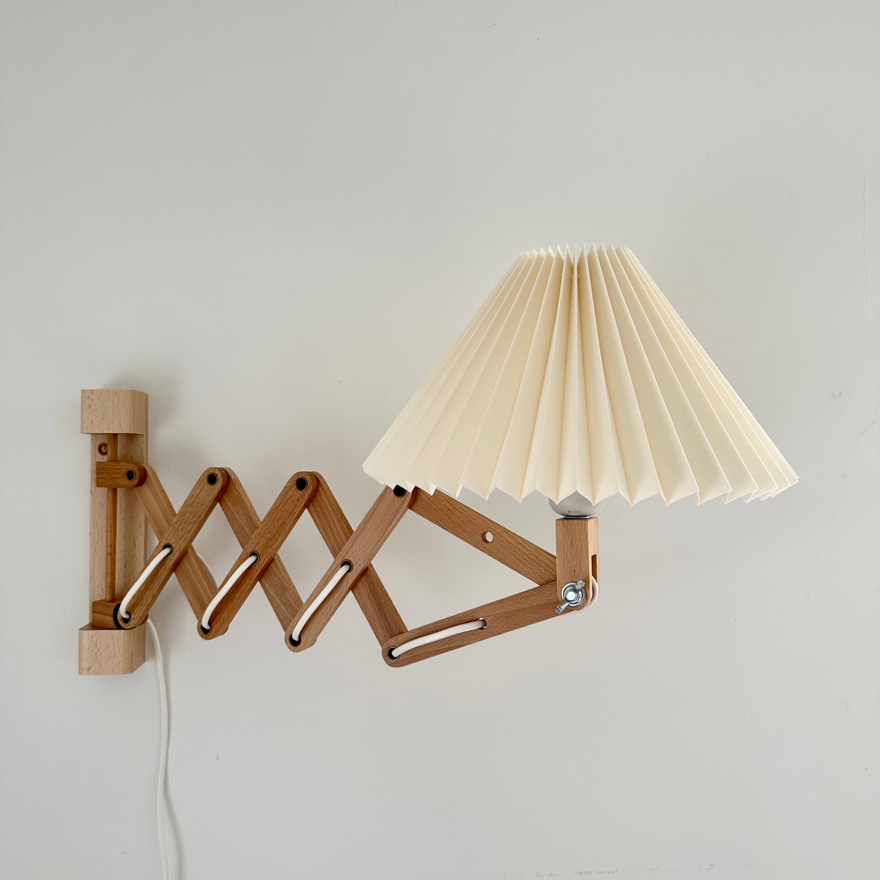 Dansk designet væglampe i bøgetræ med harmonika/saks og øvre skærm.