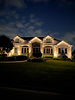 Warm white architectural lighting and landscape uplighting on a Chicago suburban stone home, installed by Accu-Bright