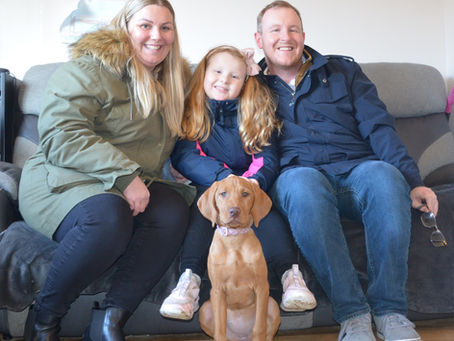 Family with their trained dog sitting calmly