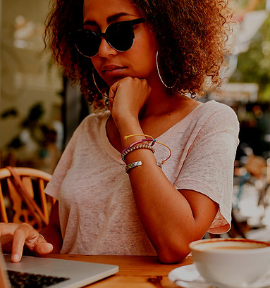 young millennial women having coffee looking on her lap top