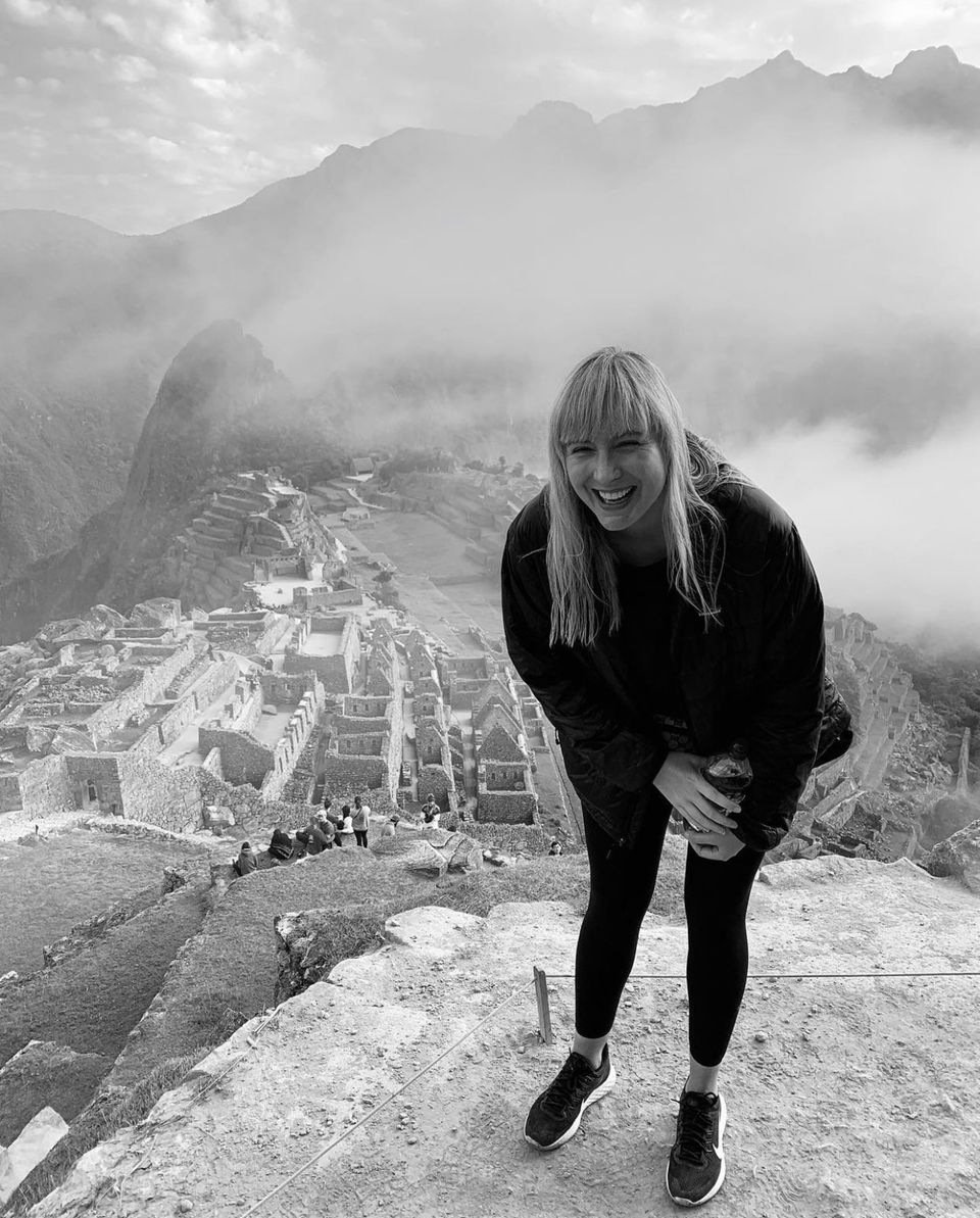 Black and white photo of a woman above Macchu Picchu