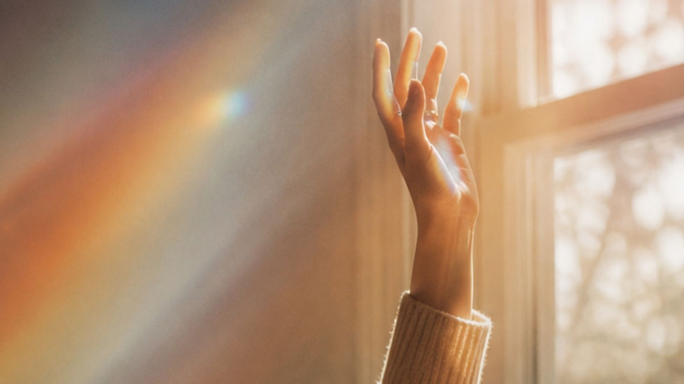 Hand reaching up to light coming from a window