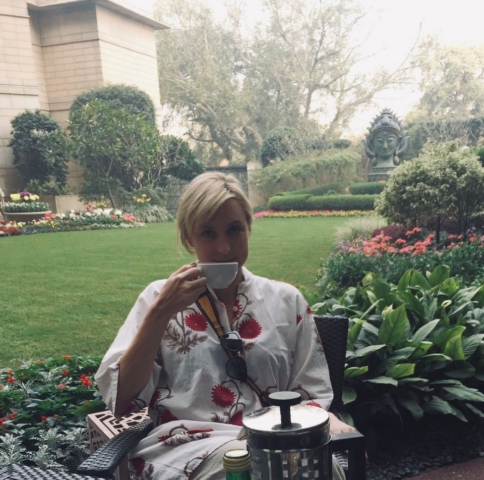 Woman sipping tea in a misty garden