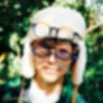 smiling boy in sherpa hat wearing many pairs of eye glasses