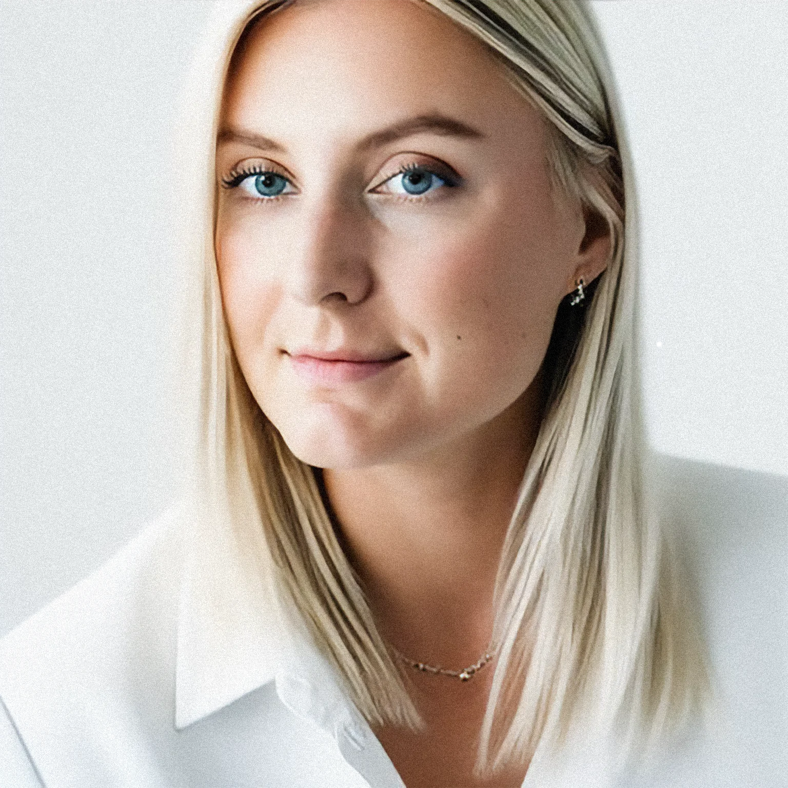 Photo of professional blonde woman with blue eyes and a soft smile