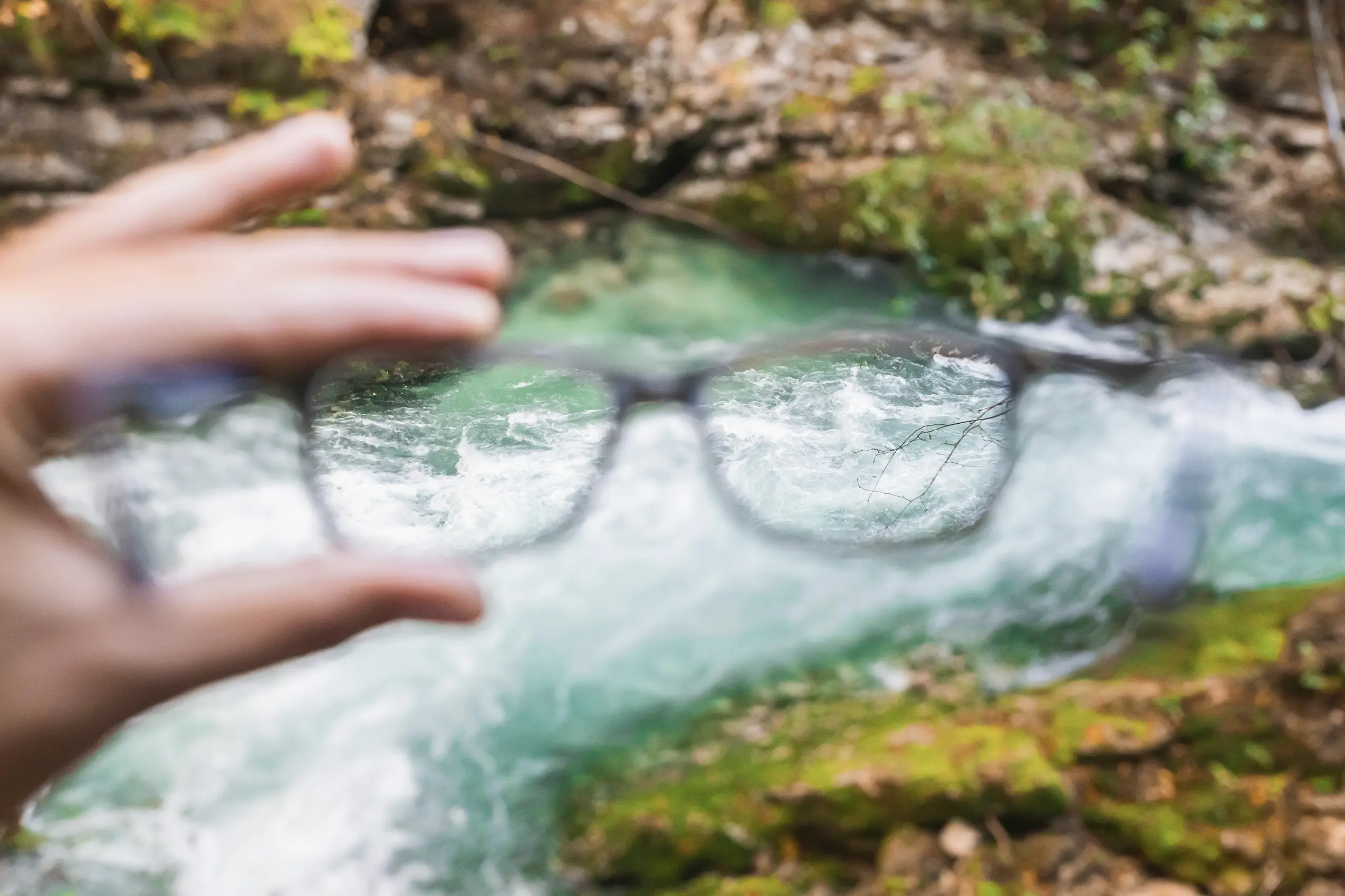 Glasses and a blurry creek