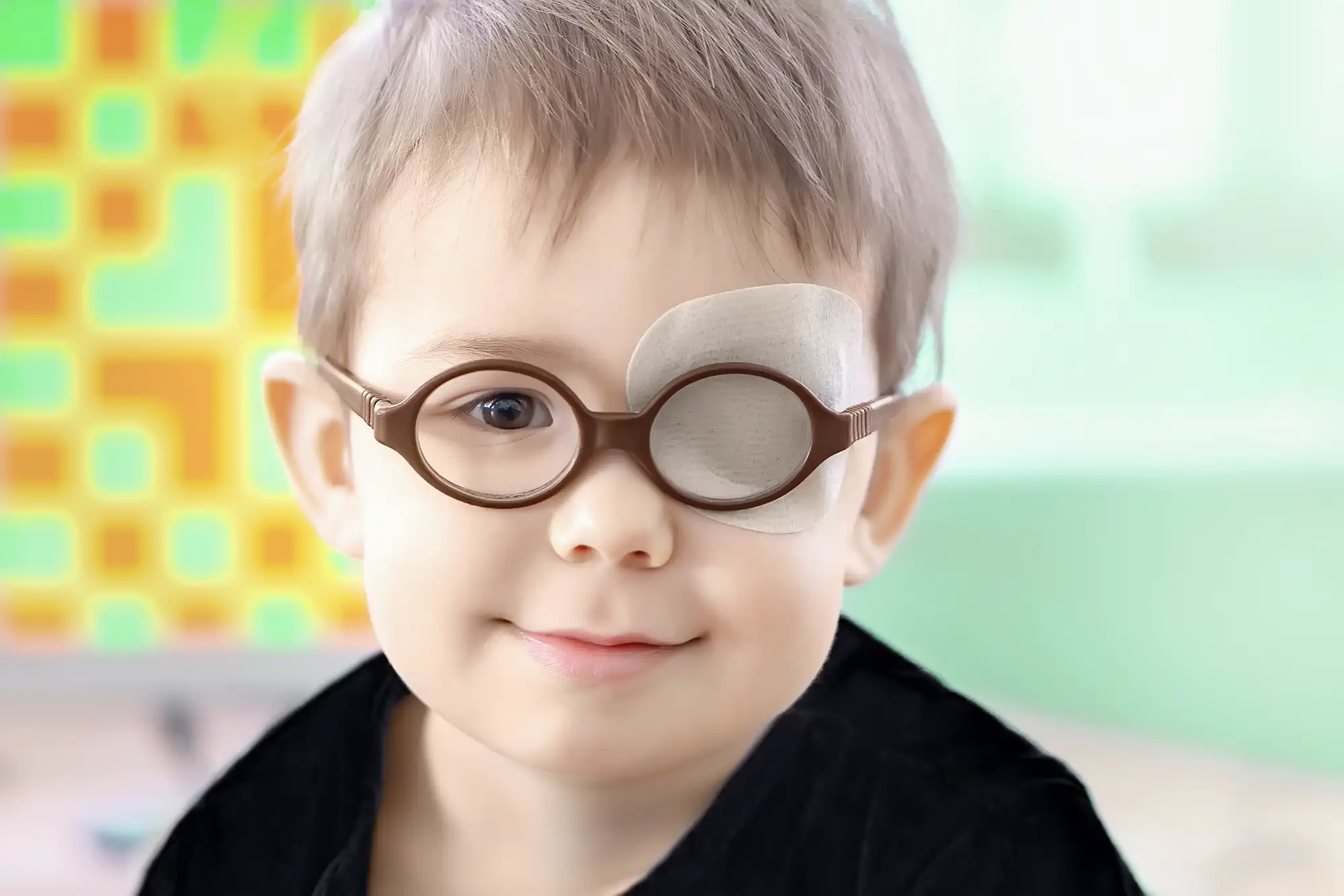 Young boy with glasses and an eye patch