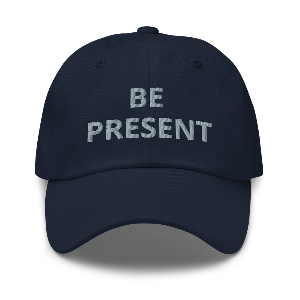 Navy embroidered dad hat featuring the statement BE PRESENT.