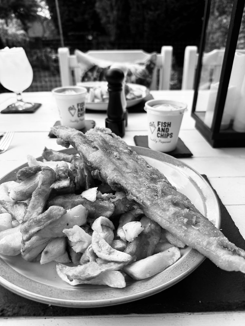 Fish and Chips food on the garden patio table during a relaxed summer evening with family.